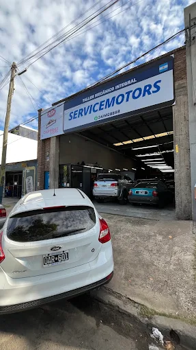Frente del taller ServiceMotors en Santa Fe 5280, con el cartel que imita una patente